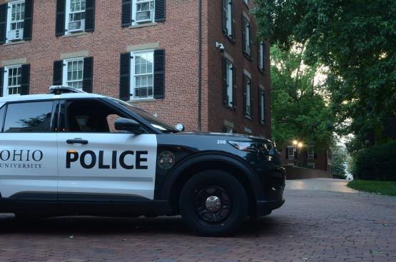 An Ohio University Police vehicle is parked near Wilson Hall on the College Green