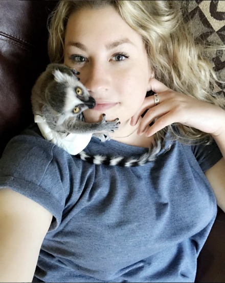 Sara McClaskey is shown with a small animal sitting on her neck