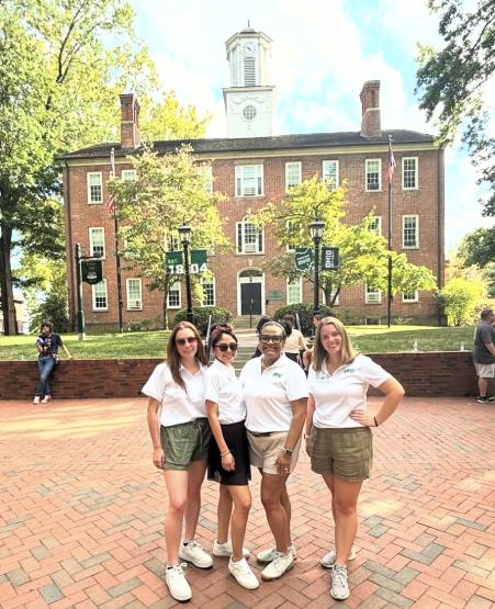 Four individuals from Sorority and Fraternity Life stand in front of Cutler Hall