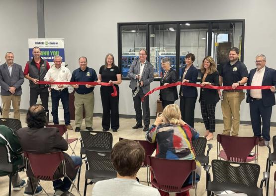 Individuals cut the ribbon while a crowd watches to celebrate the opening of the new Engineering Technology Lab