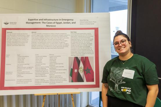 Alyssa Manning is shown standing next to a poster for her research project