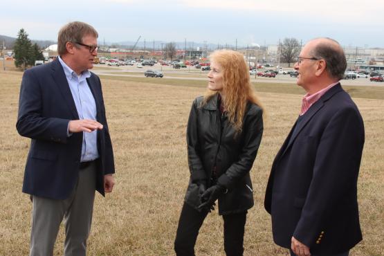 Individuals talk while standing in an open field at the PORTS site