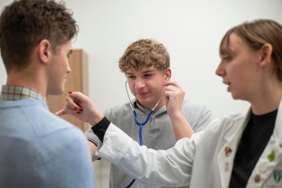 Medical student for a day participants use stethoscope