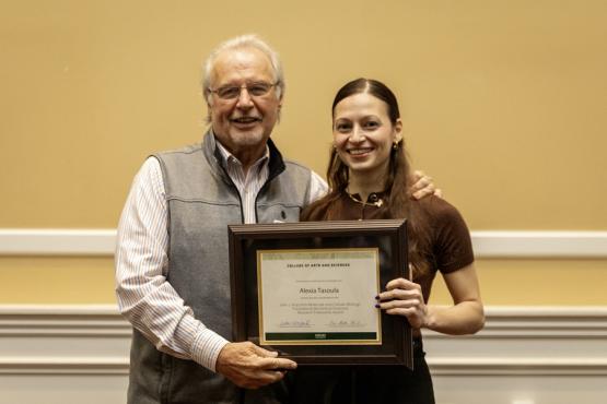 John Kopchick and Alexia Tasoula hold the award
