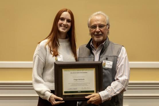 John Kopchick and Paige Herfurth hold the award