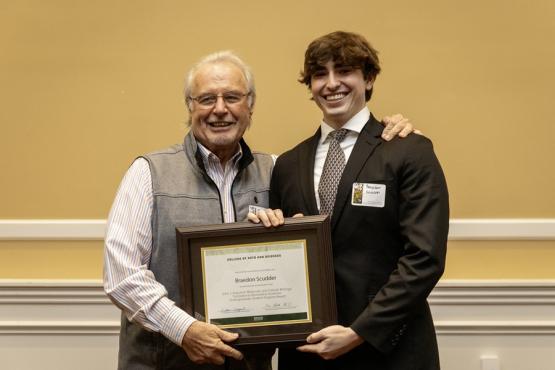 John Kopchick and Braedon Scudder hold the award