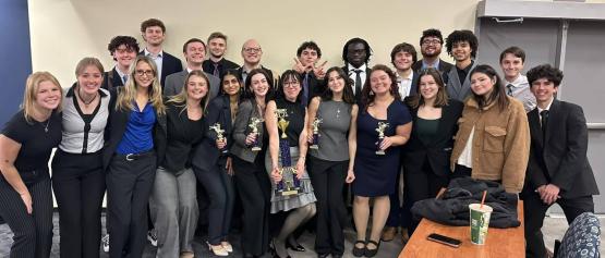 A group of students pose with trophies