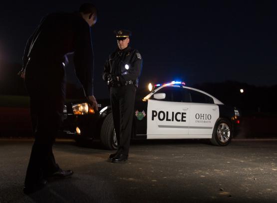 a police officer approaches a mock suspect