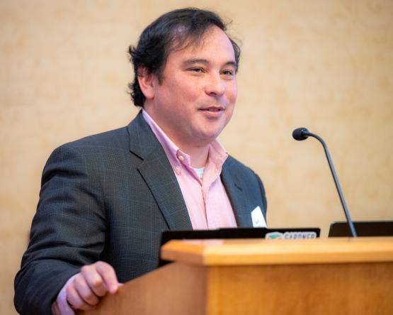 University College Dean Dave Nguyen speaks at the podium at the T1 Summit