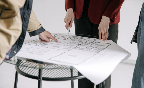 professionals looking at interior architecture blueprint on stool