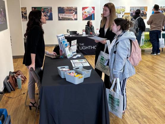 Two OHIO students talk to a representative at a booth at the Social Work Resource Fair at Ohio University Lancaster