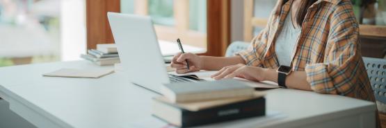 An individual works on a computer while sitting at a table