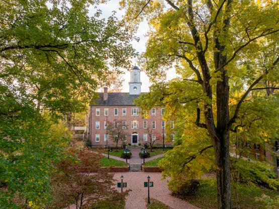 Cutler Hall is shown surrounded by trees on a sunny day in the fall