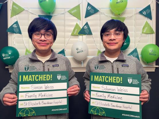 Solomon and Simon Weiss holding Match Day signs