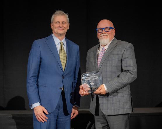 Provost Don Leo and Thom Stevenson hold the Provost Award for Excellence in Teaching