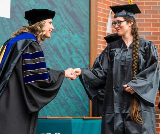 An OHIO Southern graduate shakes hands with an OHIO leader during the 2026 Graduation Recognition Ceremony