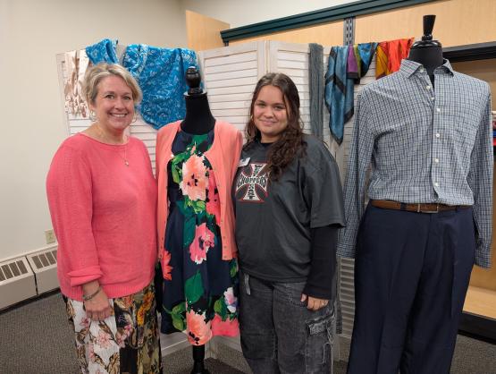 Two women standing beside clothing display