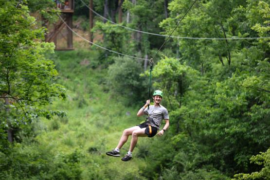 Cat Camp participant swings on zipline