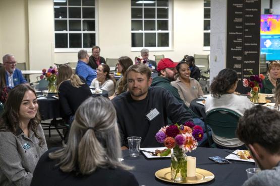 Scripps Young Alumni Council members sit at tables and talk with OHIO students, faculty and staff