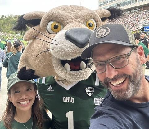 Gregg Patner stands with OHIO's Rufus mascot and another individual at an OHIO football game in Peden Stadium