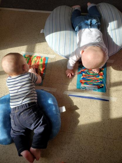 Two babies are shown crawling at the Child Development Center