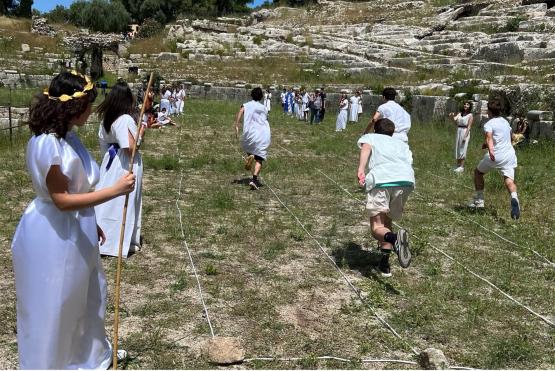 People in traditional Greek dress race through a field