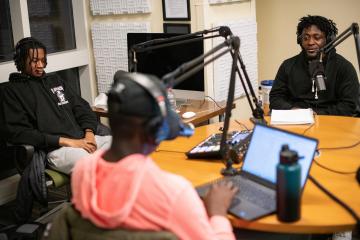 Andrew Owusu, Osahon Ogbebor, and Adam Ward are shown in the podcast studio