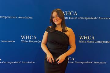 Maddie Harden poses in front of a White House Correspondent's Dinner background