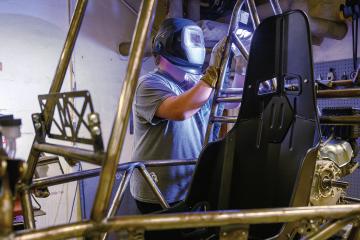 a student welds the frame of what will become an off-road vehicle