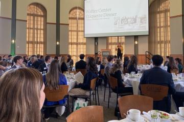 OHIO students and IGS Energy representatives sit at tables and listen to a speaker during the Etiquette Dinner in the Walter Hall Rotunda