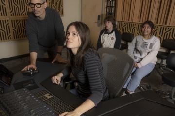 Students work in recording studio with professional