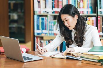 A university student studies at a computer at her local library