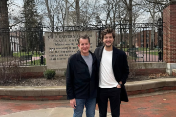 Father and son pose for a photo