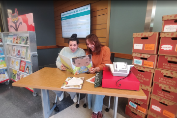 People reading a book at table