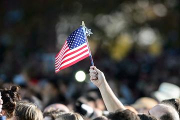 An American flag is waved amid a crowd