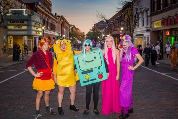 A group of students poses in colorful costumes