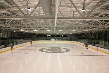 The new ice is shown inside of Bird Arena. Two people are shown skating on the ice in the background.