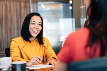 two women sitting at a table talking