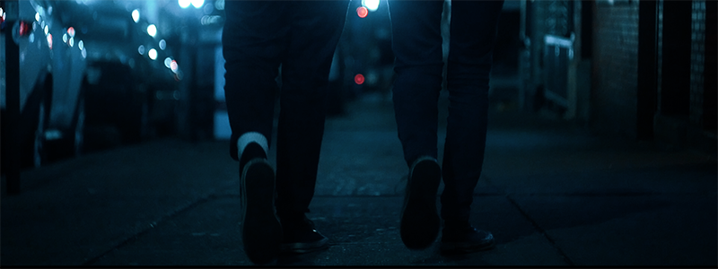 Still of Start by Believing documentary; people walking on dark sidewalk