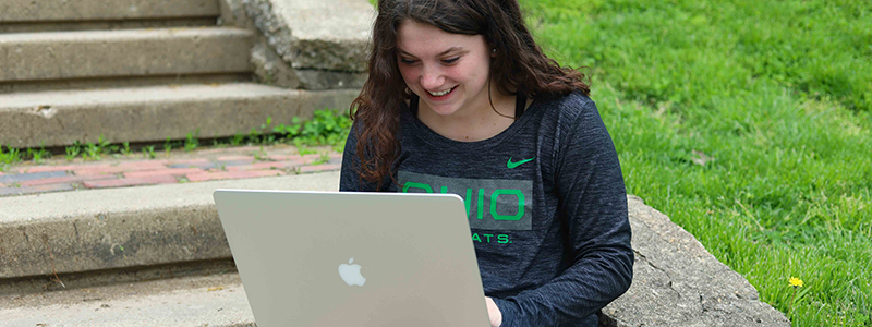 Student using laptop and wearing Bobcat Depot merchandise