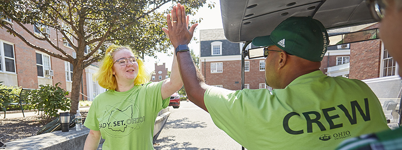 Jason Pina high-fiving a student in the move-in crew