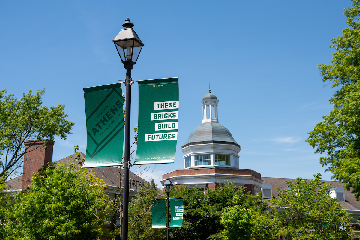 lamp post with OHIO banners with Baker Center in the background