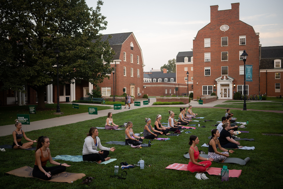 students taking a yoga class outside on West Green