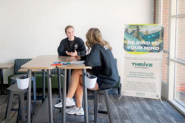 student talks to peer educator about resources