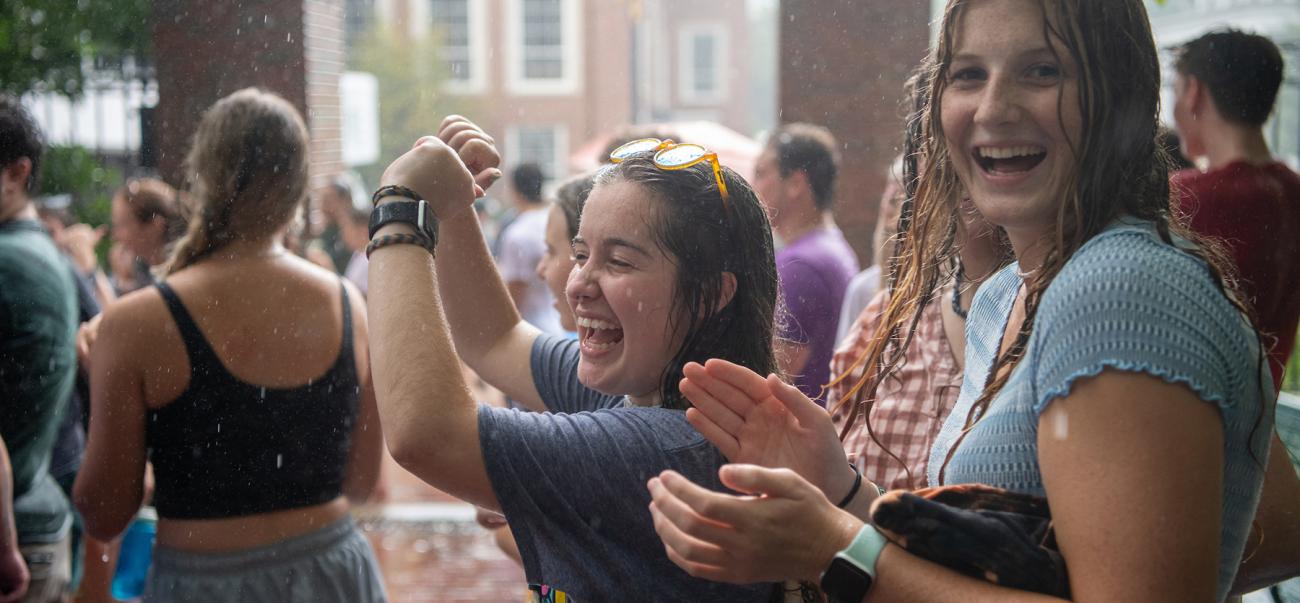 Students laughing in rain at involvement fair 2021