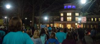 Participants in the Take Back the Night event stand outside Baker University Center in silence
