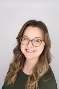 Woman wearing glasses smiling at the camera