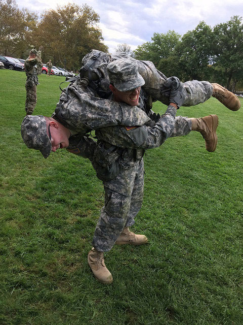 One cadet holding another on his shoulders