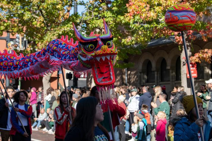 Asian American advocacy organizations march in the homecoming parade with a Chinese paper dragon