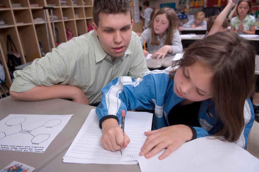 A teacher candidate helps a student at Alexander School district